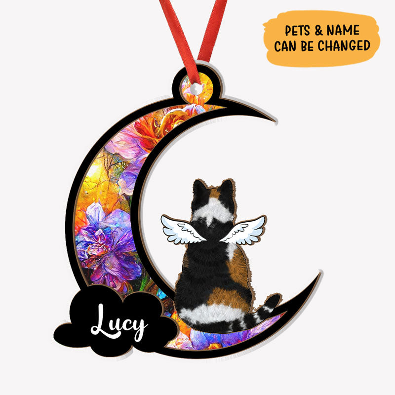 A personalized suncatcher ornament in the shape of a crescent moon with a picture of a dog breed and the name 'Sadie' printed on it. The ornament is hanging by a string and appears to be placed in front of a light source, creating a colorful reflection.