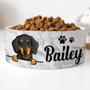 Custom ceramic dog bowl with a grey marble pattern, featuring a personalized name 'Bailey' in cursive script, and an illustration of a dog's face and paw prints in black.